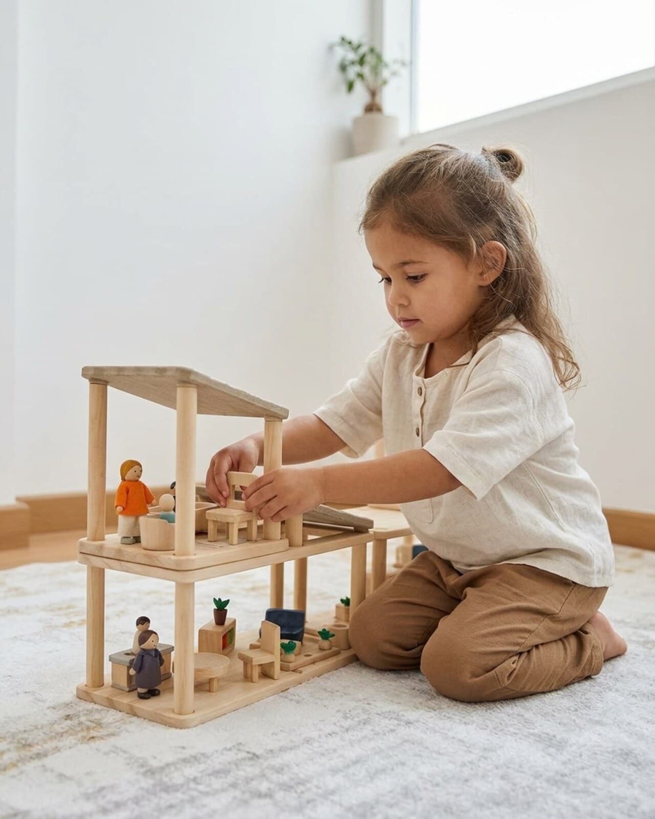 A child absorbed in a wooden dollhouse